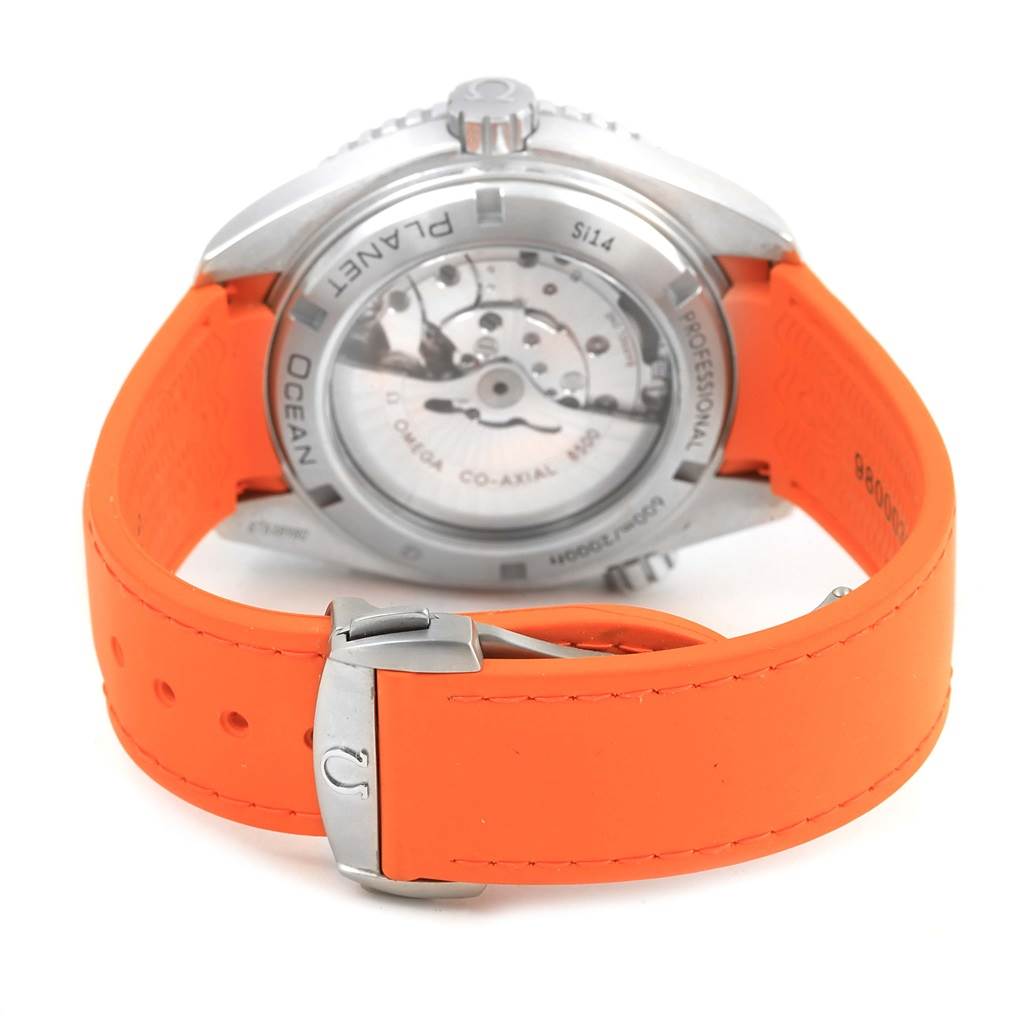 The image shows the back view of an Omega Planet Ocean 232.32.46.21.01.001 Men
s Stainless Steel Black Dial 232.32.46.21.01.001 Men
s Stainless Steel Black Dial watch with an orange strap and visible movement.