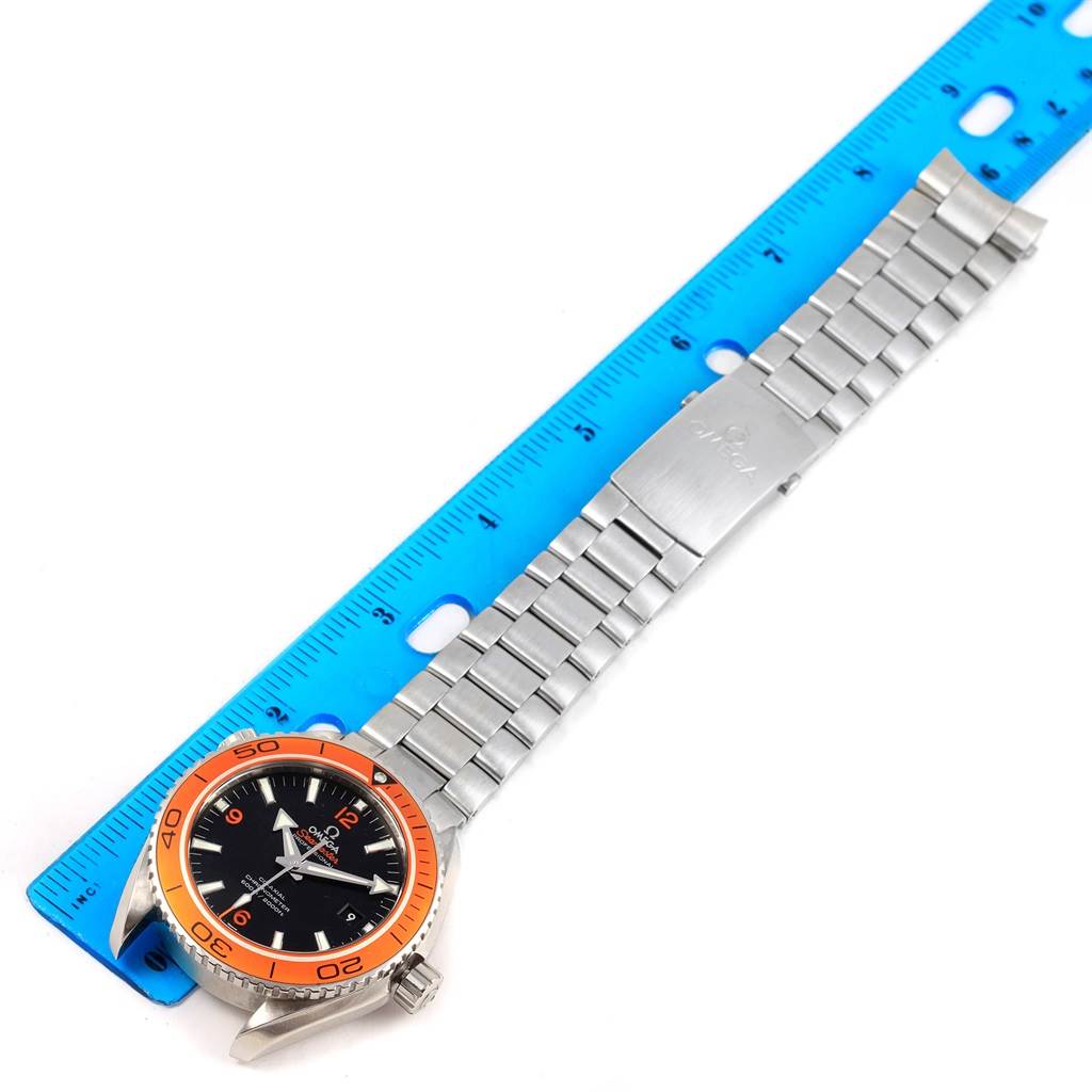 The Omega Planet Ocean 232.30.46.21.01.002 Men's Stainless Steel Black Dial 232.30.46.21.01.002 Men's Stainless Steel Black Dial watch is shown flat with its bracelet extended, alongside a ruler for scale.