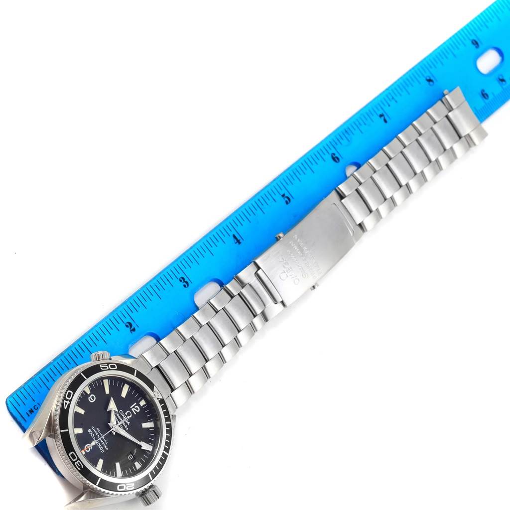 The Omega Planet Ocean 2201.50.00 Men's Stainless Steel Black Dial 2201.50.00 Men's Stainless Steel Black Dial watch is shown from an overhead angle with its stainless steel bracelet laid flat and measured against a blue ruler.