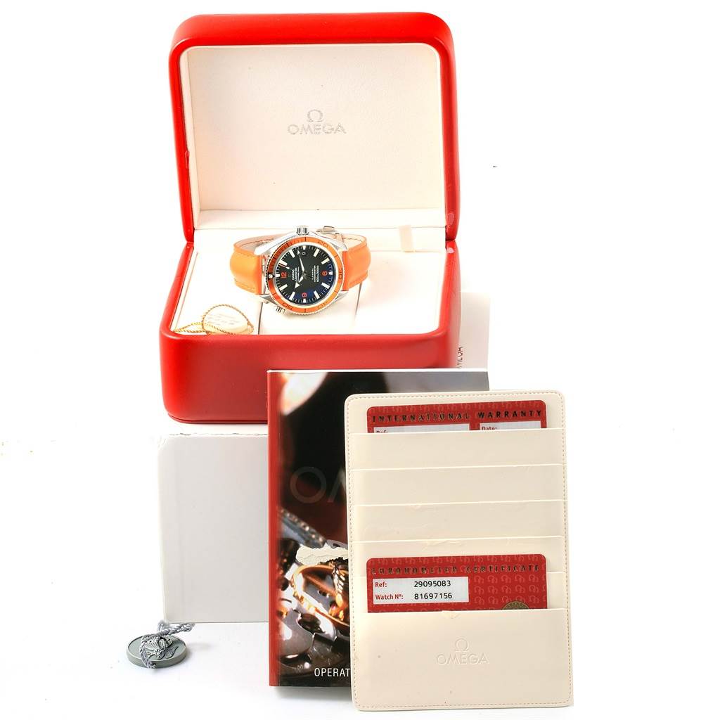 The image shows the Omega Planet Ocean 2909.50.83 Men
s Stainless Steel Black Dial 2909.50.83 Men
s Stainless Steel Black Dial watch in its red box, along with its warranty cards and an Omega booklet.