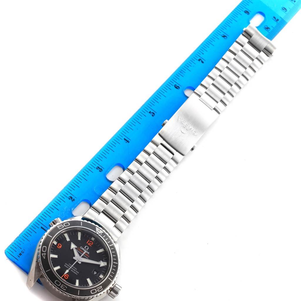 The image shows an Omega Planet Ocean 232.30.46.21.01.003 Men
s Stainless Steel Black Dial 232.30.46.21.01.003 Men
s Stainless Steel Black Dial watch laying flat with the front face and metal bracelet next to a blue ruler.