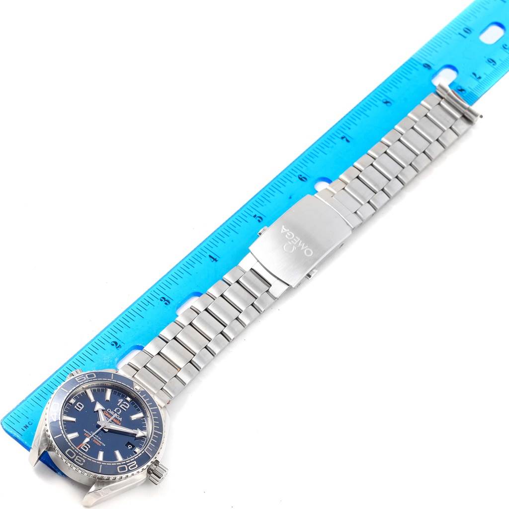 The Omega Planet Ocean 215.30.40.20.03.001 Men's Stainless Steel Blue Dial 215.30.40.20.03.001 Men's Stainless Steel Blue Dial model watch is displayed flat with its full bracelet and clasp visible next to a blue ruler for scale.