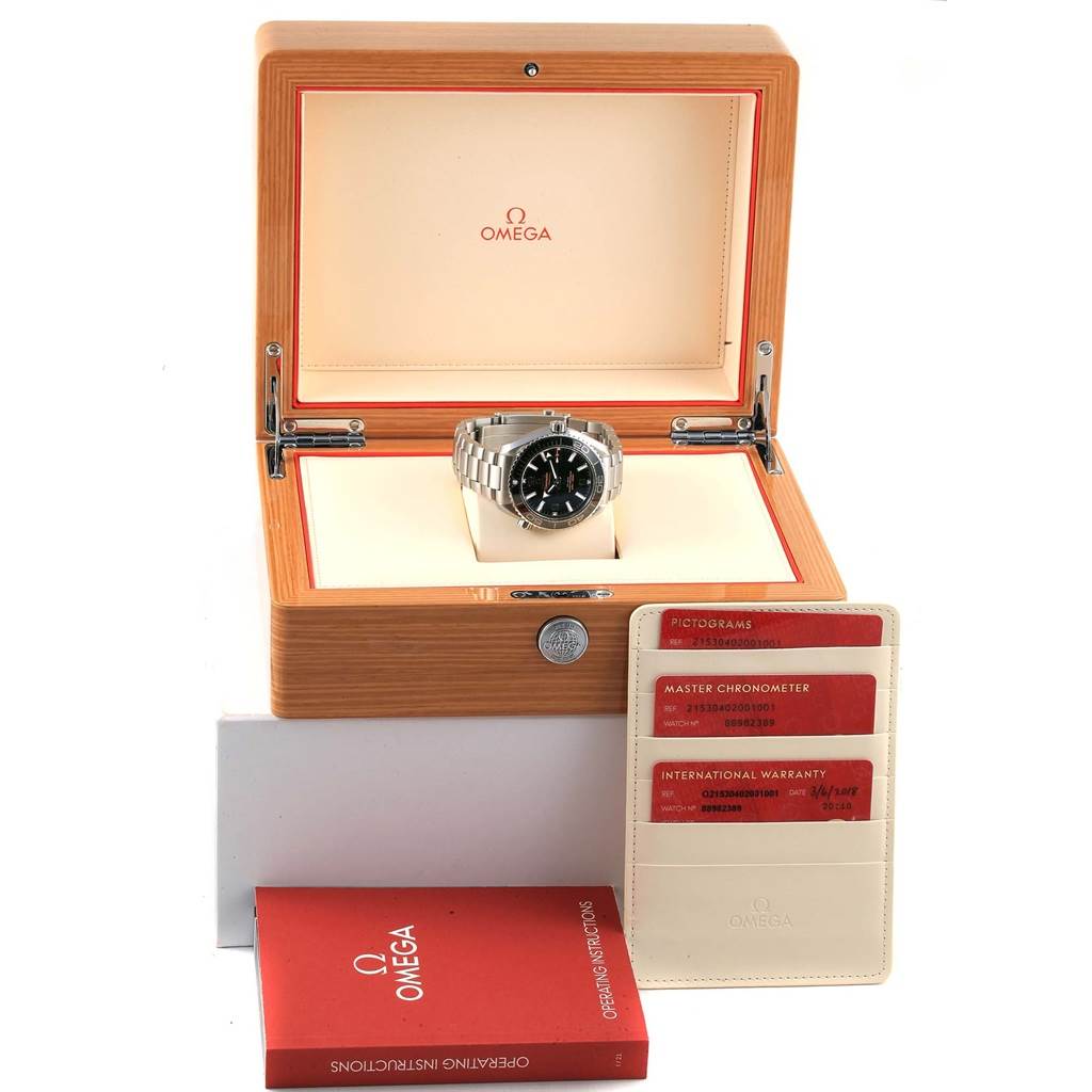 The image shows an Omega Planet Ocean 215.30.40.20.01.001 Men's Stainless Steel Black Dial 215.30.40.20.01.001 Men's Stainless Steel Black Dial watch set in a wooden box, accompanied by a cardholder and user manual.