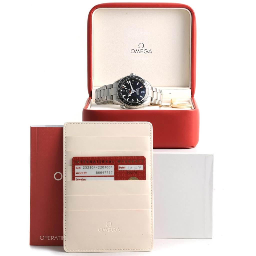 The Omega Planet Ocean 232.30.44.22.01.001 Men's Stainless Steel Black Dial 232.30.44.22.01.001 Men's Stainless Steel Black Dial watch is displayed in its open box, along with the warranty card, booklet, and cardholder.