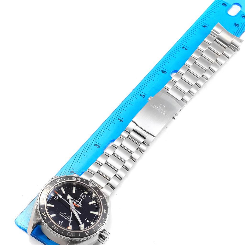 This image shows the top view of an Omega Planet Ocean 232.30.44.22.01.001 Men
s Stainless Steel Black Dial 232.30.44.22.01.001 Men
s Stainless Steel Black Dial watch, displaying its face, bracelet, and clasp next to a ruler.