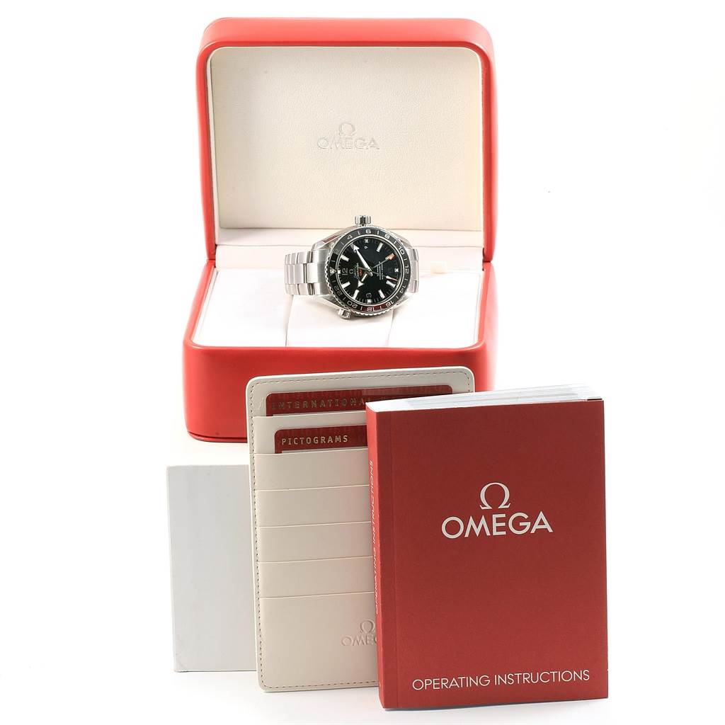 The image shows an Omega Planet Ocean 232.30.44.22.01.001 Men
s Stainless Steel Black Dial 232.30.44.22.01.001 Men
s Stainless Steel Black Dial watch in its box, along with the operating instructions and warranty cards displayed.