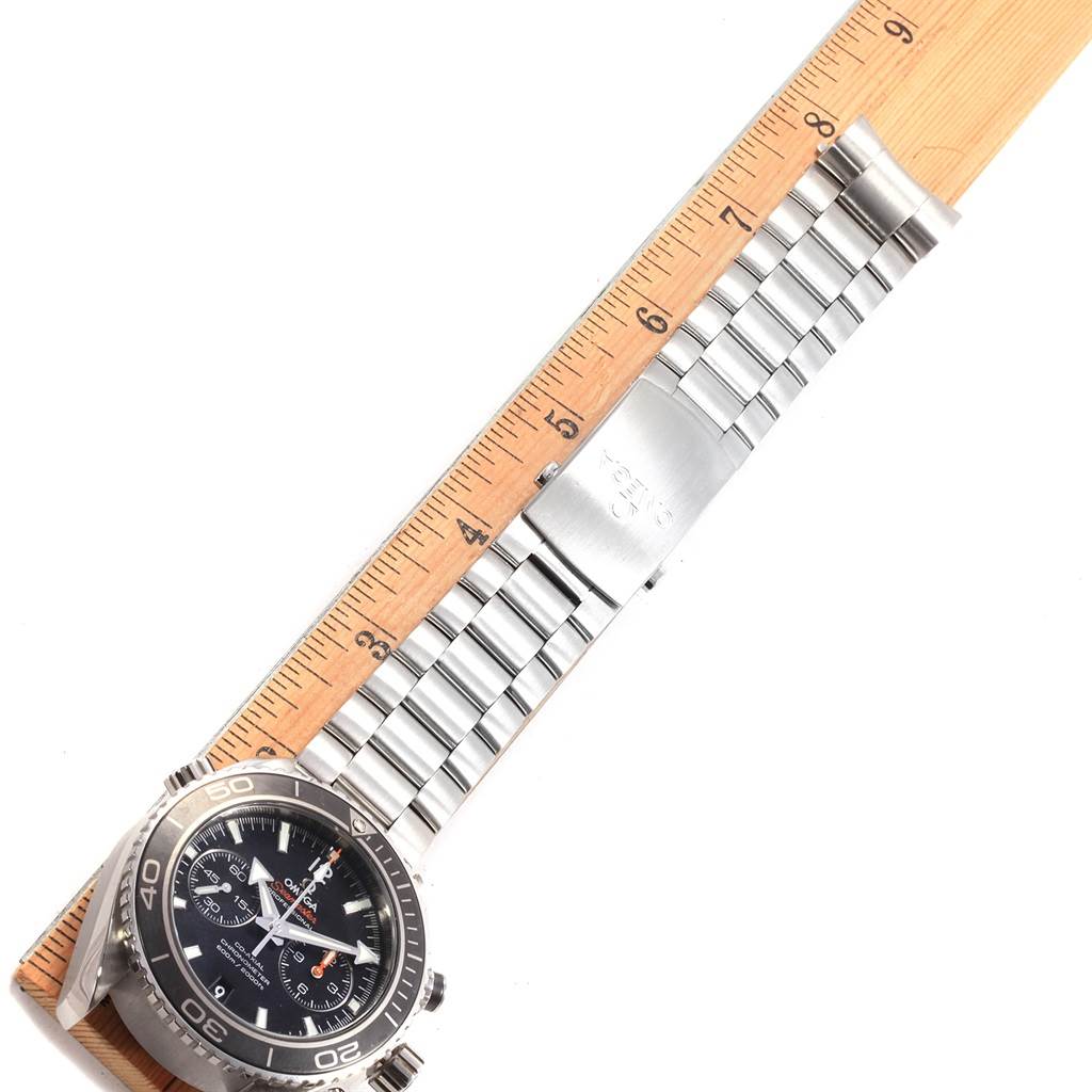 The Omega Planet Ocean 232.30.46.51.01.003 Men's Stainless Steel Black Dial 232.30.46.51.01.003 Men's Stainless Steel Black Dial watch is shown at an angle, showcasing its bezel, dial, and metal bracelet with a ruler for scale.