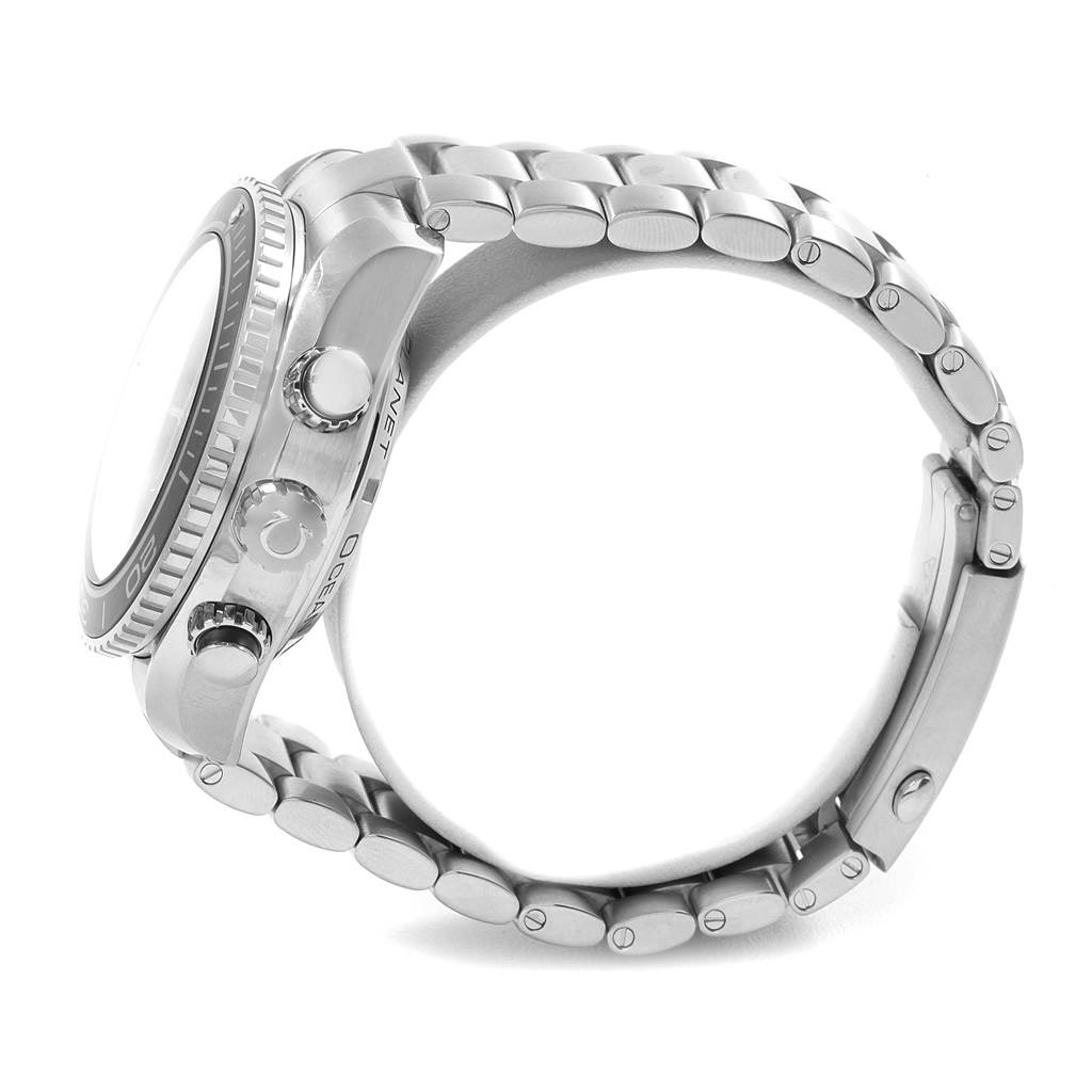 The image shows a side angle of the Omega Planet Ocean 232.30.46.51.01.003 Men
s Stainless Steel Black Dial 232.30.46.51.01.003 Men
s Stainless Steel Black Dial watch, displaying its crown, pushers, and metal bracelet.