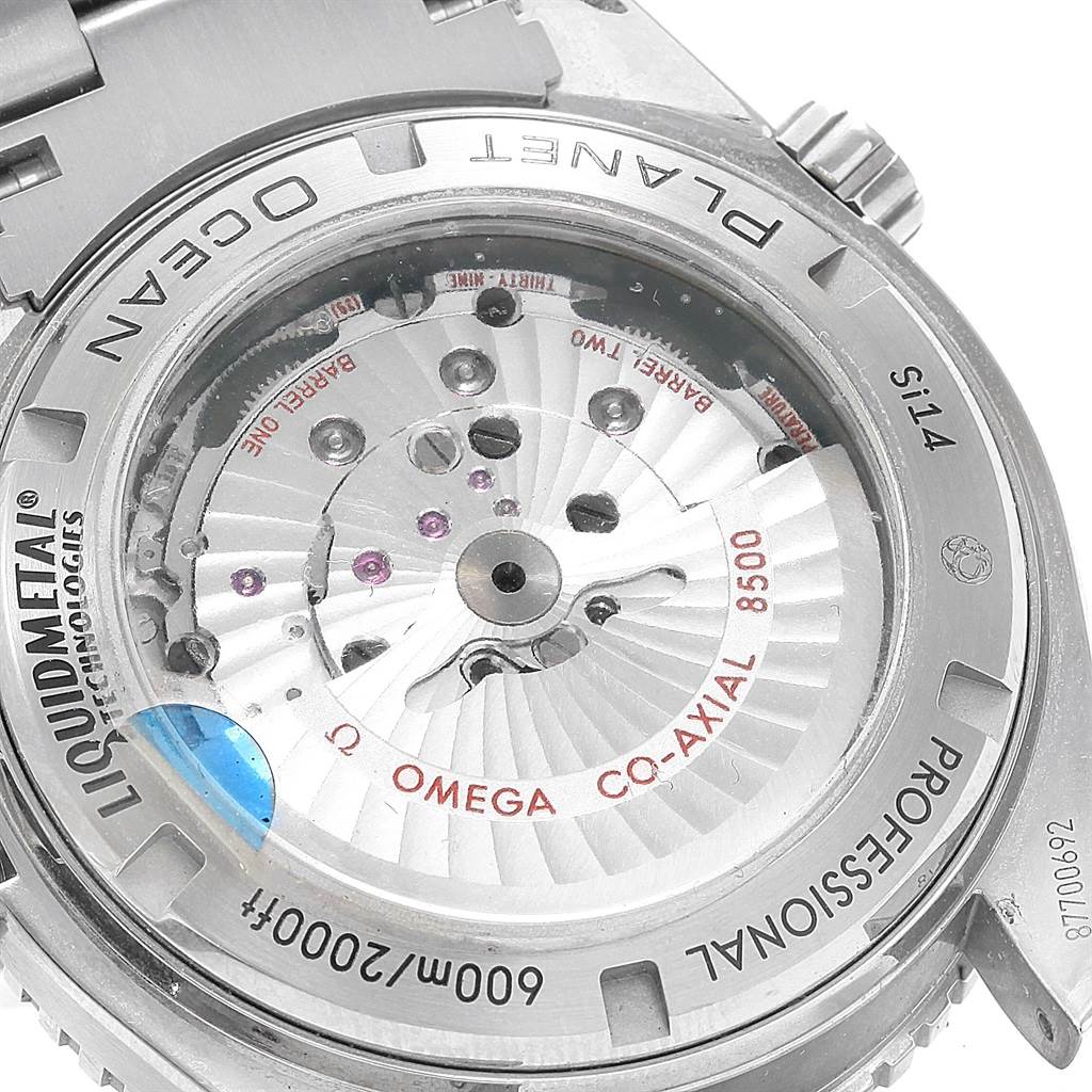 The image shows the back view of the Omega Planet Ocean 232.90.46.21.03.001 Men's Titanium Blue Dial 232.90.46.21.03.001 Men's Titanium Blue Dial watch, highlighting the internal mechanics and "Liquidmetal" technology.