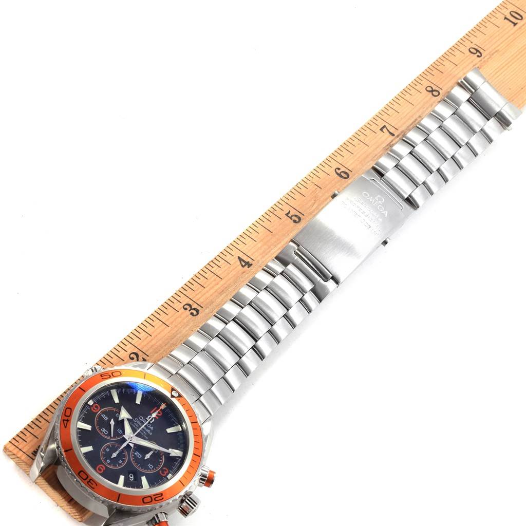 The image shows an Omega Planet Ocean 2218.50.00 Men
s Stainless Steel Black Dial 2218.50.00 Men
s Stainless Steel Black Dial watch laid flat, measured with a ruler, displaying the face and full bracelet.