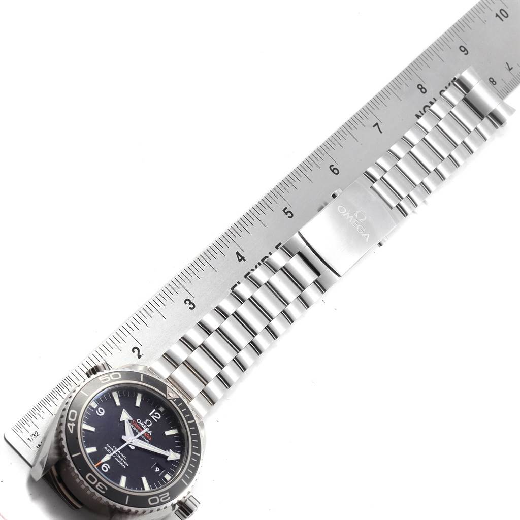 The image shows an Omega Planet Ocean 232.30.46.21.01.001 Men
s Stainless Steel Black Dial 232.30.46.21.01.001 Men
s Stainless Steel Black Dial watch with a metal bracelet, positioned next to a ruler for scale.