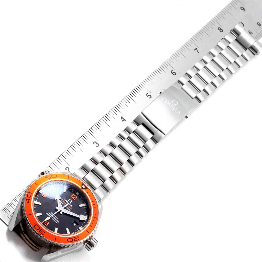 The Omega Planet Ocean 232.30.46.21.01.002 Men
s Stainless Steel Black Dial 232.30.46.21.01.002 Men
s Stainless Steel Black Dial watch is shown from a top-down angle, highlighting its orange bezel, black dial, and stainless steel bracelet.