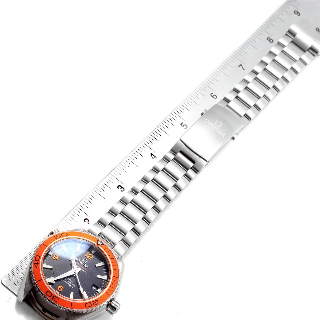 The Omega Planet Ocean 232.30.42.21.01.002 Men
s Stainless Steel Black Dial 232.30.42.21.01.002 Men
s Stainless Steel Black Dial watch is shown from a top-down angle, featuring its face, bezel, and metal bracelet laid beside a ruler.