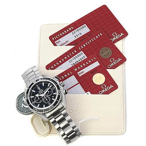 The image shows an Omega Planet Ocean 22105000 OR 2210.   50.   00 Men's Stainless Steel Black Dial 22105000 OR 2210.   50.   00 Men's Stainless Steel Black Dial watch with a stainless steel bracelet, alongside its pictograms card, chronometer certificate, and international warranty card.