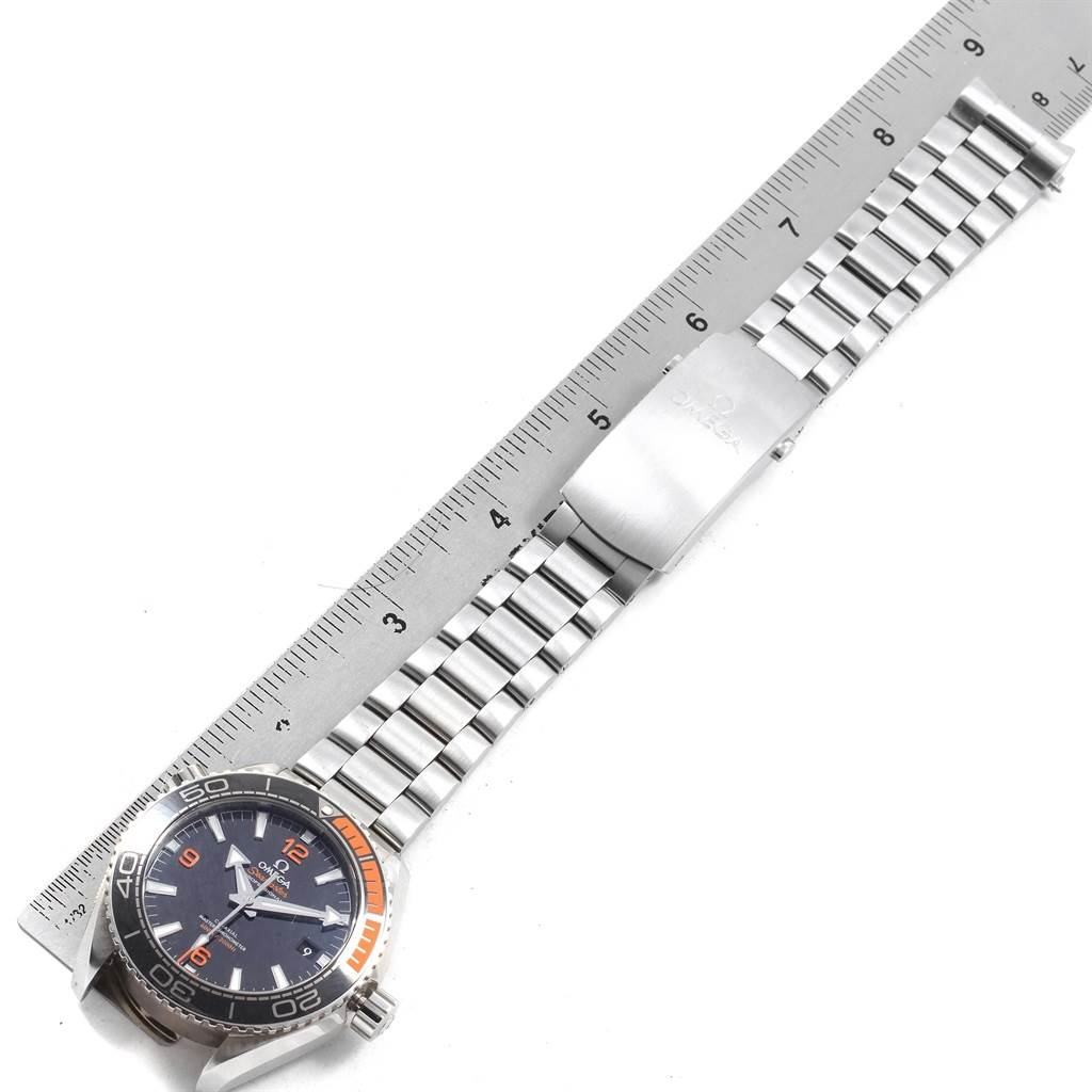 The Omega Planet Ocean 215.30.44.21.01.002 Men
s Stainless Steel Black Dial 215.30.44.21.01.002 Men
s Stainless Steel Black Dial watch is shown from a top-down angle, highlighting its face, stainless steel bracelet, and clasp next to a ruler.