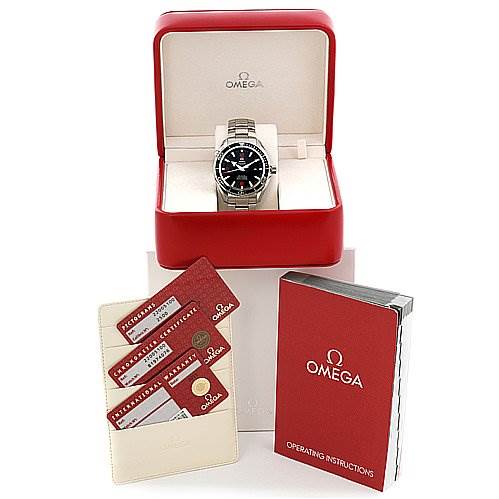The image shows an Omega Planet Ocean 22005100 OR 2200.   51.   00 Men
s Stainless Steel Black Dial 22005100 OR 2200.   51.   00 Men
s Stainless Steel Black Dial watch in its box, accompanied by warranty cards, a certificate, and the operating instructions booklet.