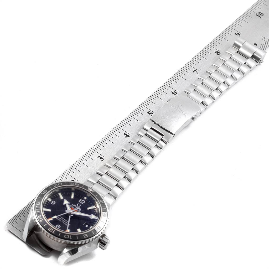 The image shows the Omega Planet Ocean 232.30.44.22.01.001 Men
s Stainless Steel Black Dial 232.30.44.22.01.001 Men
s Stainless Steel Black Dial watch with a metal bracelet laid flat against a ruler, displaying its length.