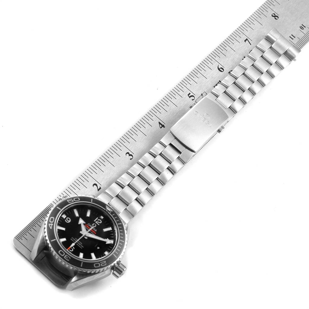 The image shows the Omega Planet Ocean 232.30.42.21.01.003 Men
s Stainless Steel Black Dial 232.30.42.21.01.003 Men
s Stainless Steel Black Dial watch laid flat with a stainless steel bracelet measured by a ruler.