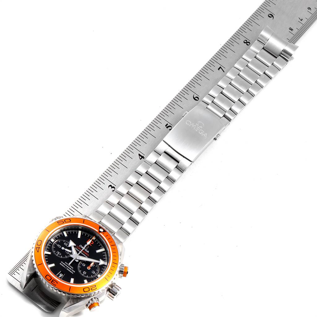 The Omega Planet Ocean 232.30.46.51.01.002 Men
s Stainless Steel Black Dial 232.30.46.51.01.002 Men
s Stainless Steel Black Dial watch is displayed flat, showing the face, bezel, and metal bracelet alongside a ruler for measurement.