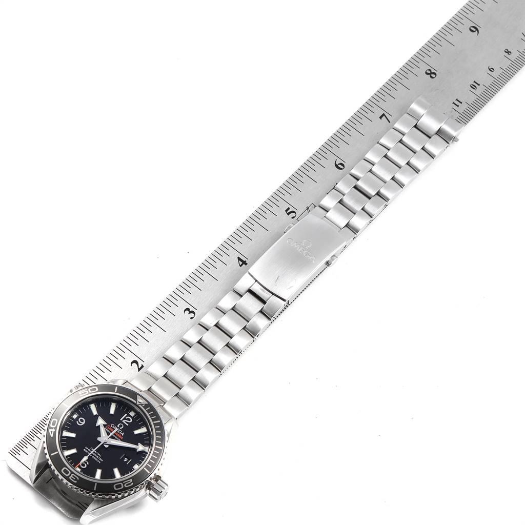 The image shows an Omega Planet Ocean 232.30.42.21.01.003 Men
s Stainless Steel Black Dial 232.30.42.21.01.003 Men
s Stainless Steel Black Dial watch laid flat with its bracelet next to a ruler for measurement.