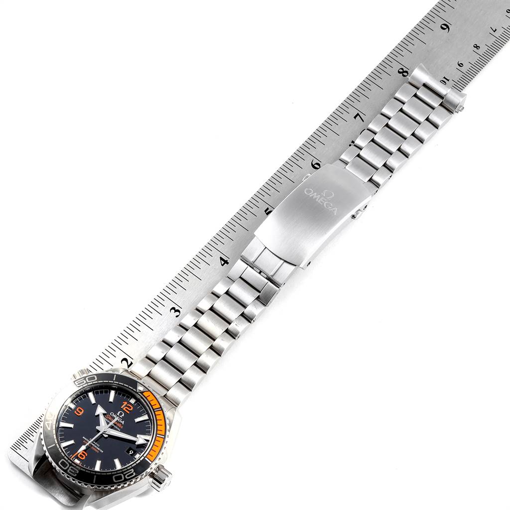 The image shows an Omega Planet Ocean 215.30.44.21.01.002 Men
s Stainless Steel Black Dial 215.30.44.21.01.002 Men
s Stainless Steel Black Dial watch laid flat on a ruler, displaying the dial, bezel, and metal bracelet.