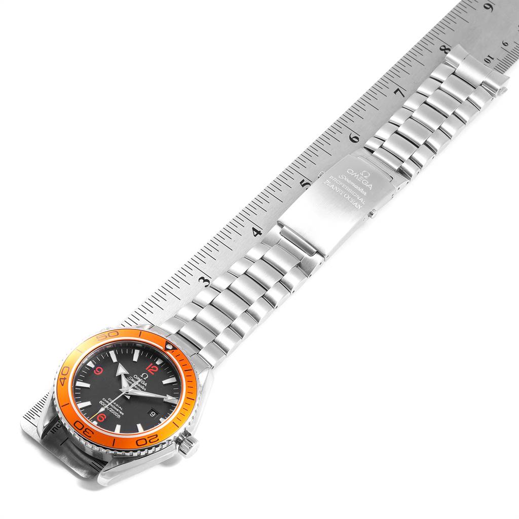 The image shows an Omega Planet Ocean 2208.50.00 Men
s Stainless Steel Black Dial 2208.50.00 Men
s Stainless Steel Black Dial watch laid flat with its band fully extended, alongside a ruler for measurement.