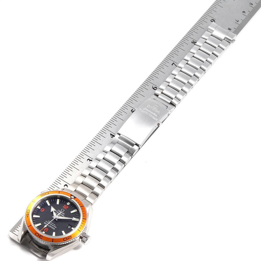 The watch is an Omega Planet Ocean 2209.50.00 Men
s Stainless Steel Black Dial 2209.50.00 Men
s Stainless Steel Black Dial model shown from an angled top-down view, highlighting the face, crown, bracelet, and clasp.