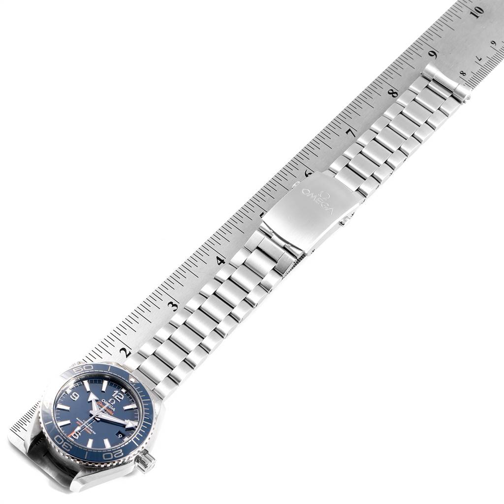 This image shows the Omega Planet Ocean 215.30.40.20.03.001 Men
s Stainless Steel Blue Dial 215.30.40.20.03.001 Men
s Stainless Steel Blue Dial watch laid flat, with a metal band and clasp extending across a measuring ruler.