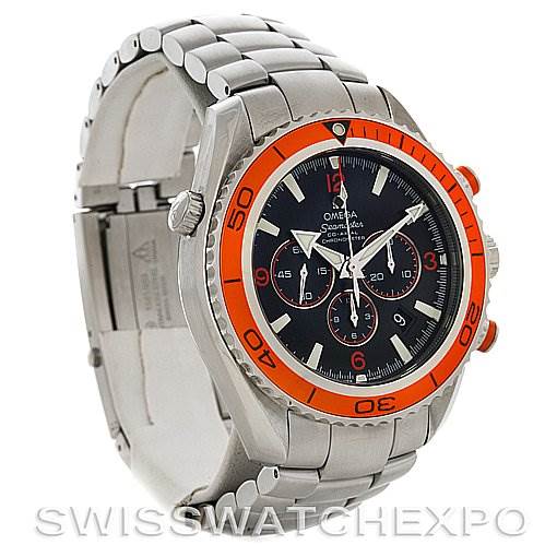 The image showcases an Omega Planet Ocean 2218.50.00 Men
s Stainless Steel Black Dial 2218.50.00 Men
s Stainless Steel Black Dial watch from an oblique angle, revealing its stainless steel bracelet, red bezel, and face.