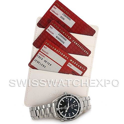 The image shows an Omega Planet Ocean 2200.50 Men's Stainless Steel Black Dial 2200.50 Men's Stainless Steel Black Dial watch with its bracelet, warranty cards, and a certificate holder.