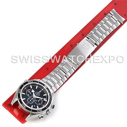 The image shows an Omega Planet Ocean 2210.51.00 Men's Stainless Steel Black Dial 2210.51.00 Men's Stainless Steel Black Dial watch with a stainless steel bracelet, laid flat alongside a red ruler.