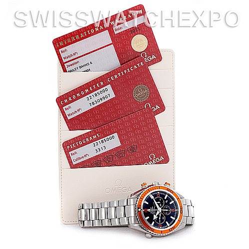 The image shows an Omega Planet Ocean 2218.50.00 Men's Stainless Steel Black Dial 2218.50.00 Men's Stainless Steel Black Dial watch, its documentation cards, and a cardholder placed beneath the cards.