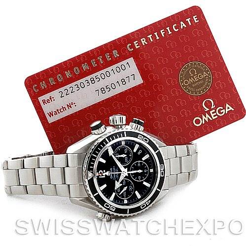 The image shows an Omega Planet Ocean 22230385001001 Stainless Steel Black Dial 22230385001001 Stainless Steel Black Dial watch from the front with a red chronometer certificate card in the background.