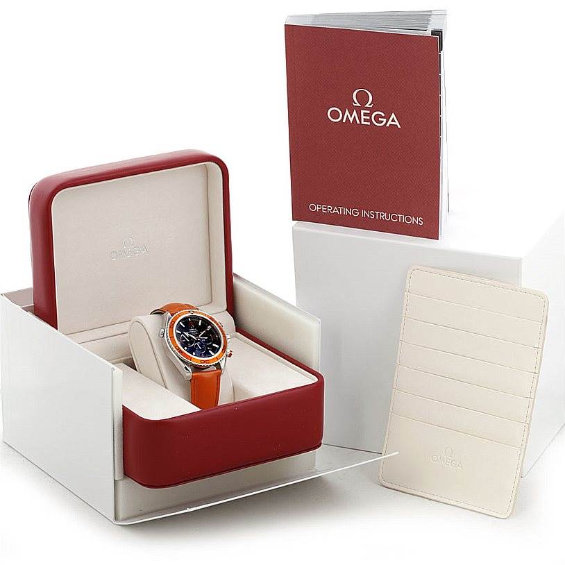 The Omega Planet Ocean 2918.50.83 Men's Stainless Steel Black Dial 2918.50.83 Men's Stainless Steel Black Dial watch is shown at a front angle in its open box, accompanied by the instruction manual and a cardholder.