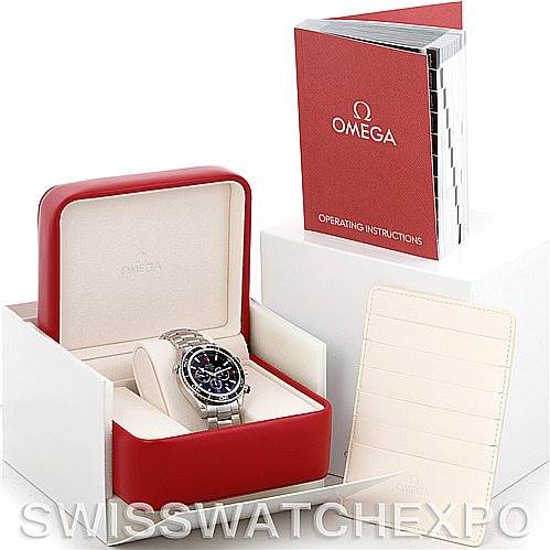 The image shows an Omega Planet Ocean 2210.51.00 Men's Stainless Steel Black Dial 2210.51.00 Men's Stainless Steel Black Dial watch in its box, along with the operating instructions and a document holder.