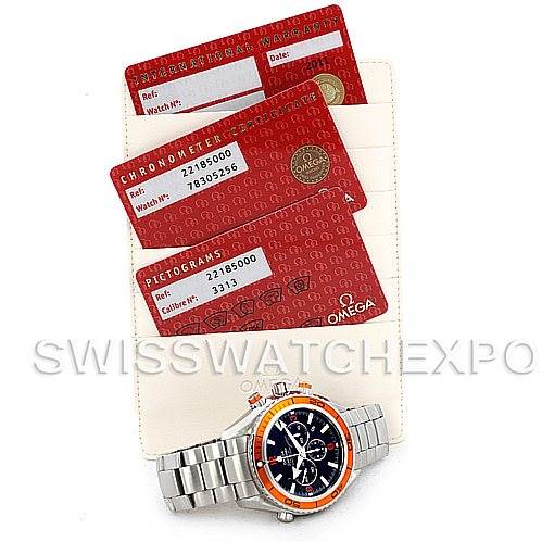 This image shows an Omega Planet Ocean 2218.50.00 Men's Stainless Steel Black Dial 2218.50.00 Men's Stainless Steel Black Dial watch along with its warranty cards and certification cards, displayed from a top-down angle.