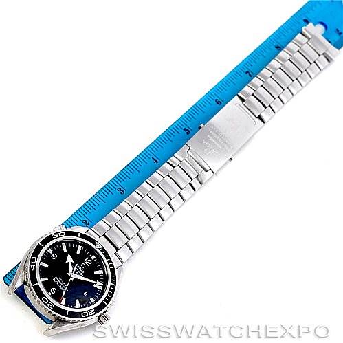 The Omega Planet Ocean 2200.50.00 Men's Stainless Steel Black Dial 2200.50.00 Men's Stainless Steel Black Dial watch is shown from a top-down angle displaying its face, bracelet, and measuring 12 inches with a blue ruler.