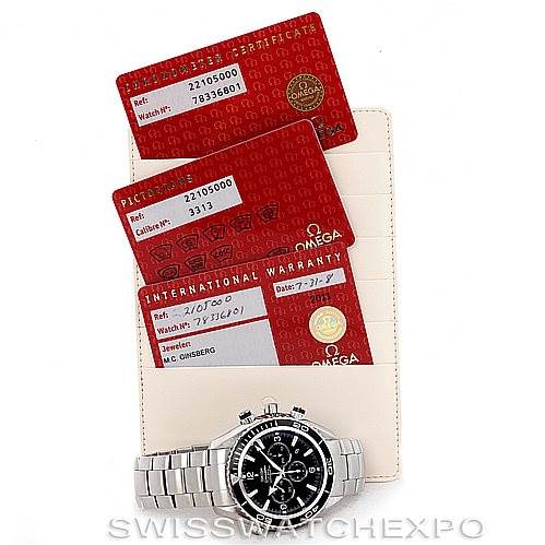 The image shows an Omega Planet Ocean 2210.50.00 Men's Stainless Steel Black Dial 2210.50.00 Men's Stainless Steel Black Dial watch from a top-down view along with warranty cards and a certificate.