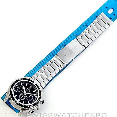 The image shows an overhead view of an Omega Planet Ocean 2210.50.00 Men's Stainless Steel Black Dial 2210.50.00 Men's Stainless Steel Black Dial watch, showcasing the dial and stainless steel bracelet next to a ruler.