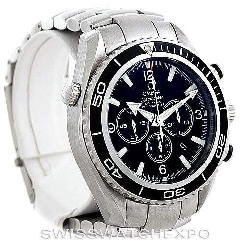 The image shows an angled view of the Omega Planet Ocean 2210.50.00 Men's Stainless Steel Black Dial 2210.50.00 Men's Stainless Steel Black Dial watch, featuring its bezel, crown, chronograph dials, and stainless steel bracelet.