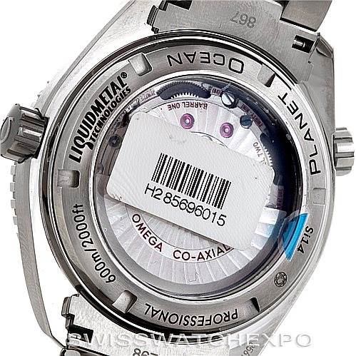 The image shows the back view of an Omega Planet Ocean 232.90.46.21.03.001 Men's Titanium Blue Dial 232.90.46.21.03.001 Men's Titanium Blue Dial watch, highlighting the Liquidmetal Technology and co-axial movement.