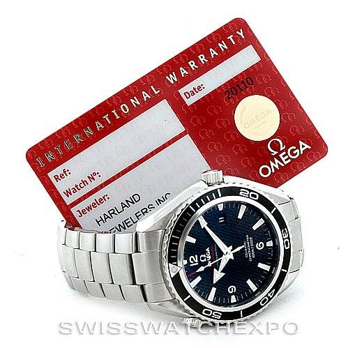 The image shows an Omega Planet Ocean 222.30.46.20.01.001 Men's Stainless Steel Black Dial 222.30.46.20.01.001 Men's Stainless Steel Black Dial watch positioned in front of an international warranty card.