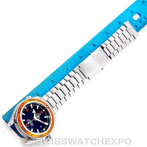 The image shows a full view of the Omega Planet Ocean 2208.50.00 Men
s Stainless Steel Black Dial 2208.50.00 Men
s Stainless Steel Black Dial watch, with its orange bezel and stainless steel bracelet, placed next to a blue ruler for scale.