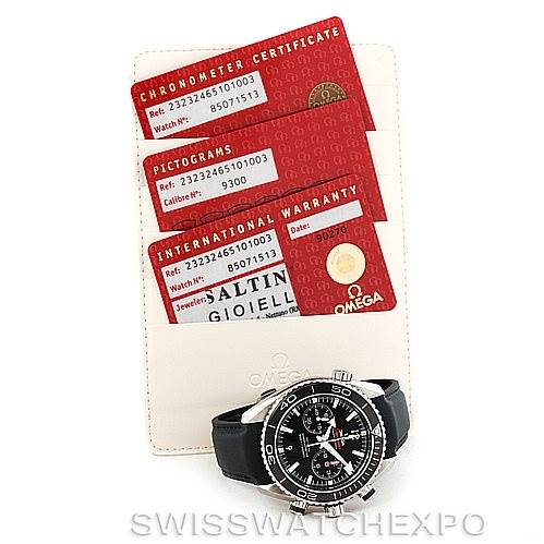 The image shows an Omega Planet Ocean 232.32.46.51.01.003 Men
s Stainless Steel Black Dial 232.32.46.51.01.003 Men
s Stainless Steel Black Dial watch placed next to its chronometer certificate, pictogram, and international warranty cards.