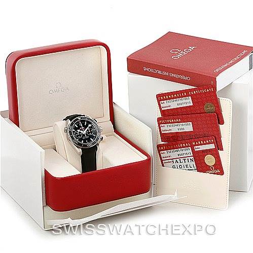 This image shows an Omega Planet Ocean 232.32.46.51.01.003 Men
s Stainless Steel Black Dial 232.32.46.51.01.003 Men
s Stainless Steel Black Dial watch in its box, along with accompanying certification cards and instruction book.