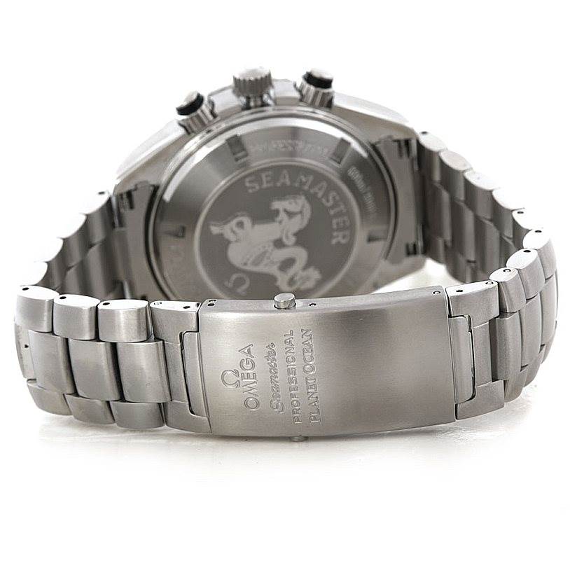 The image shows the back and clasp of an Omega Seamaster Planet Ocean watch, highlighting its stainless steel bracelet and engraved case back.
