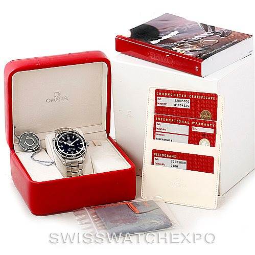 The image shows an Omega Planet Ocean 2200.50.00 Men
s Stainless Steel Black Dial 2200.50.00 Men
s Stainless Steel Black Dial watch in its box, accompanied by documentation, a warranty card, and packaging materials.