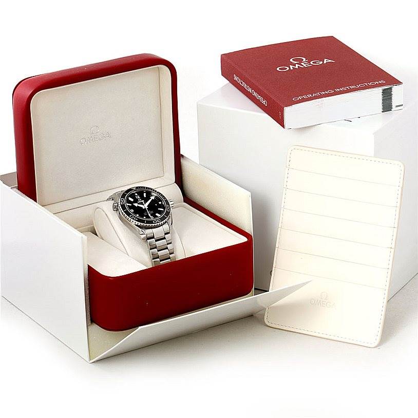 The image shows a Planet Ocean model by Omega in its box, alongside an instruction manual and a cardholder.