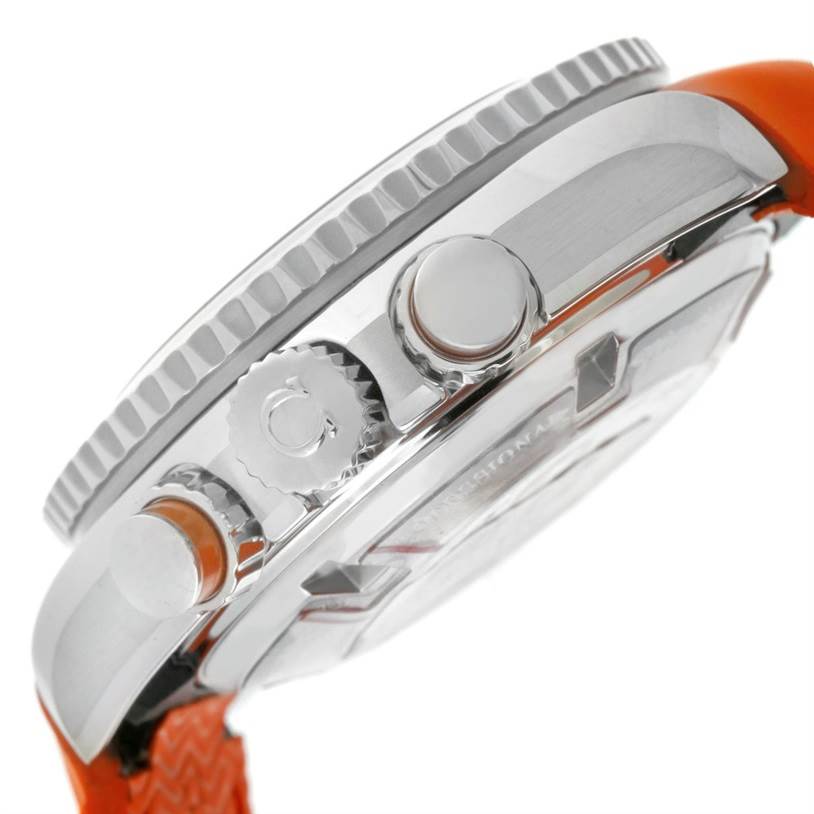 This image shows a side view of the Omega Planet Ocean 222.32.38.50.01.003 Stainless Steel Black Dial 222.32.38.50.01.003 Stainless Steel Black Dial watch, highlighting its crown, pusher, and part of the orange strap.