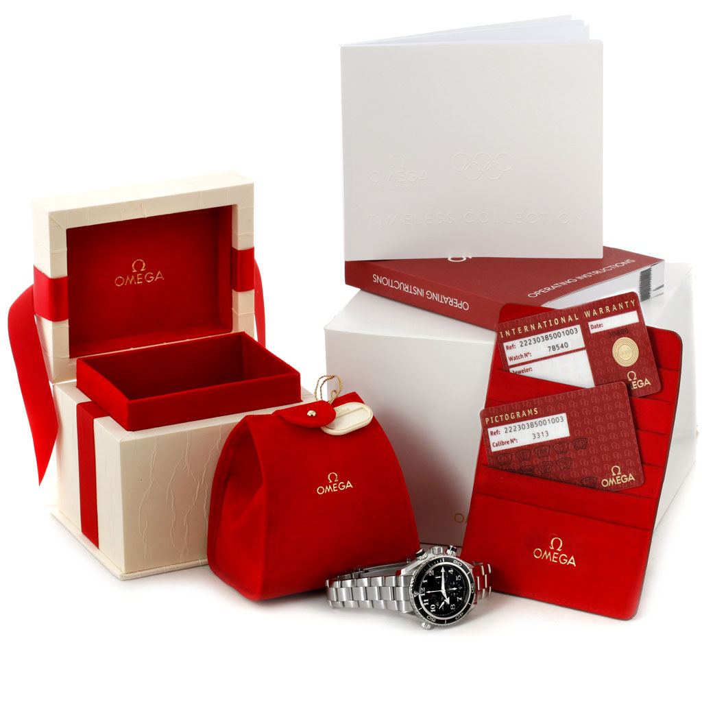 The image shows an Omega Planet Ocean 222.30.38.50.01.003 Men's Stainless Steel Black Dial 222.30.38.50.01.003 Men's Stainless Steel Black Dial watch, its box, warranty cards, a red pouch, and operation instructions all neatly displayed.